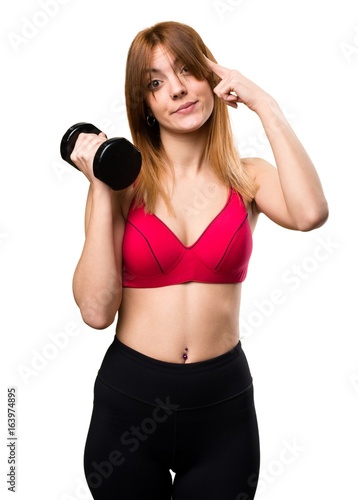 Beautiful sport woman with dumbbells thinking