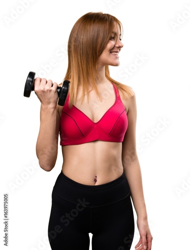 Beautiful sport woman with dumbbells looking lateral