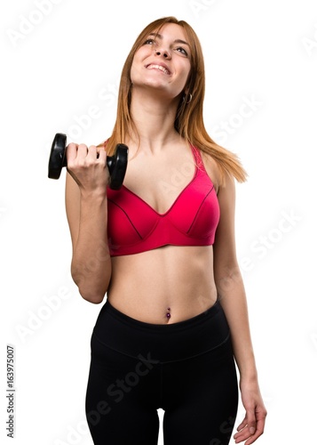 Beautiful sport woman with dumbbells looking up