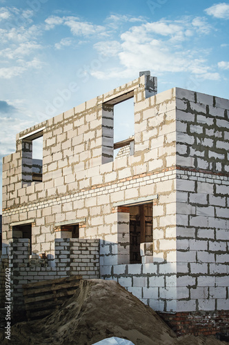 Unfinished country house of white stone blocks.