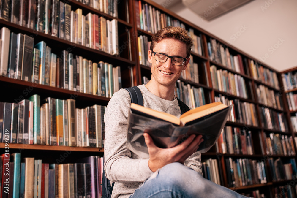 Happy university student studying in library Happy university student studying in library