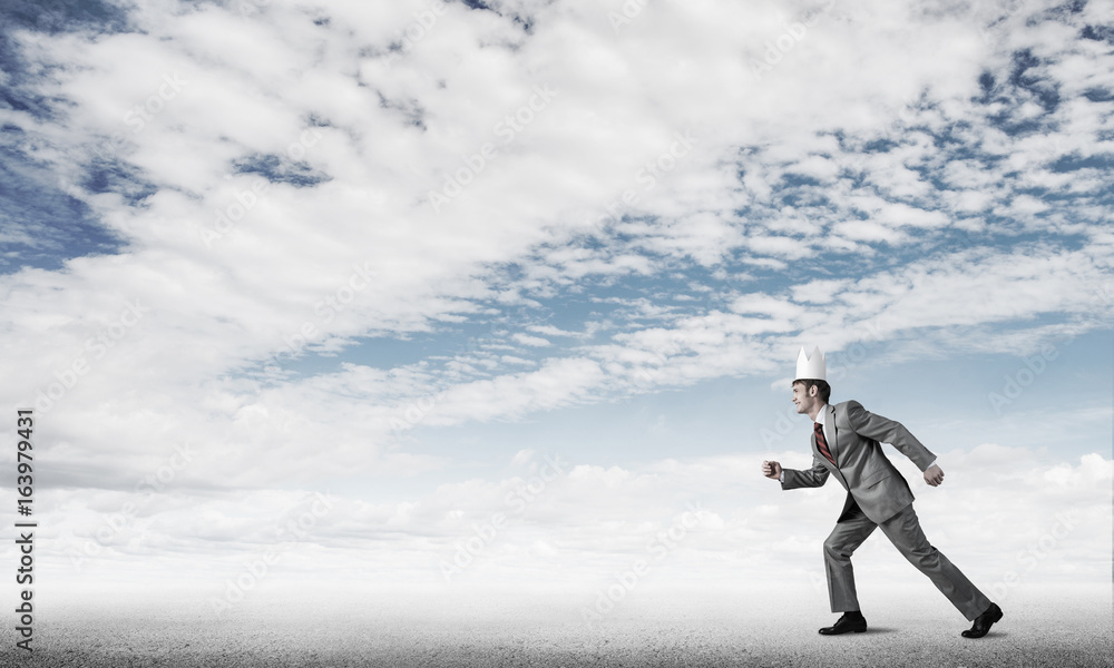 King businessman in elegant suit running and blue sky at backgro King businessman in elegant suit running and blue sky at backgro