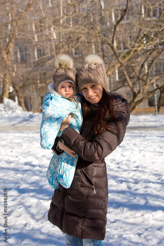 Mother and child playing in the street on a sunny winter day Mother and child playing in the street on a sunny winter day