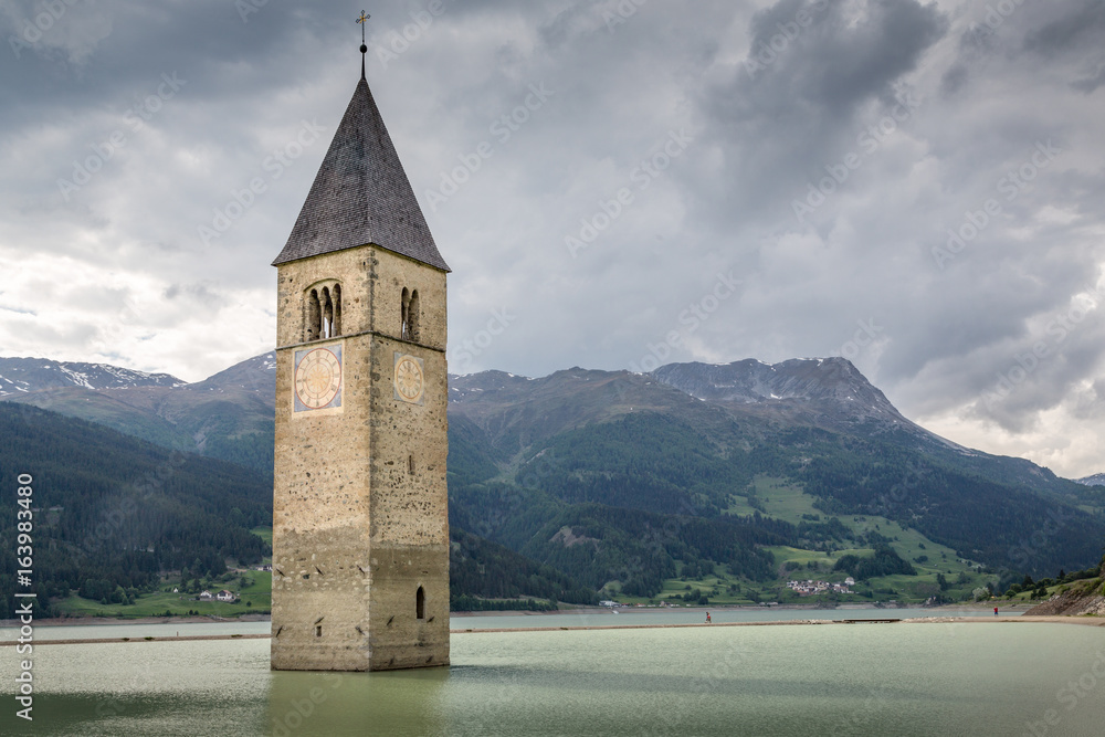 Church tower of the drowned village Graun at Reschensee in Vinschgau, South tyrol, Italy