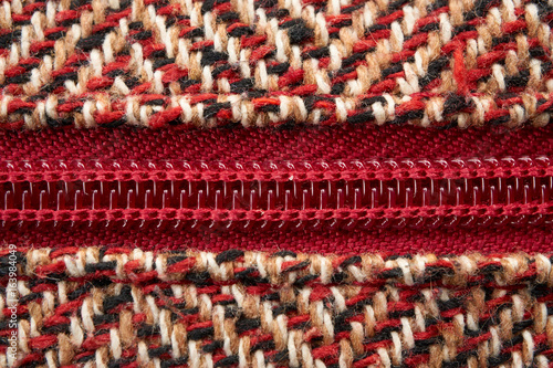 closeup of a zipper in midst of woolen pattern texture material