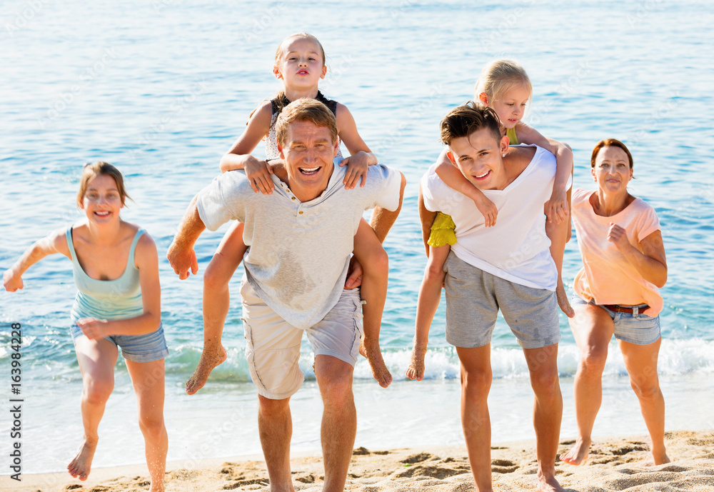 Large family happily running and carrying kids on parents back