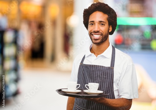 Restaurant owner with coffee cups against blurry background