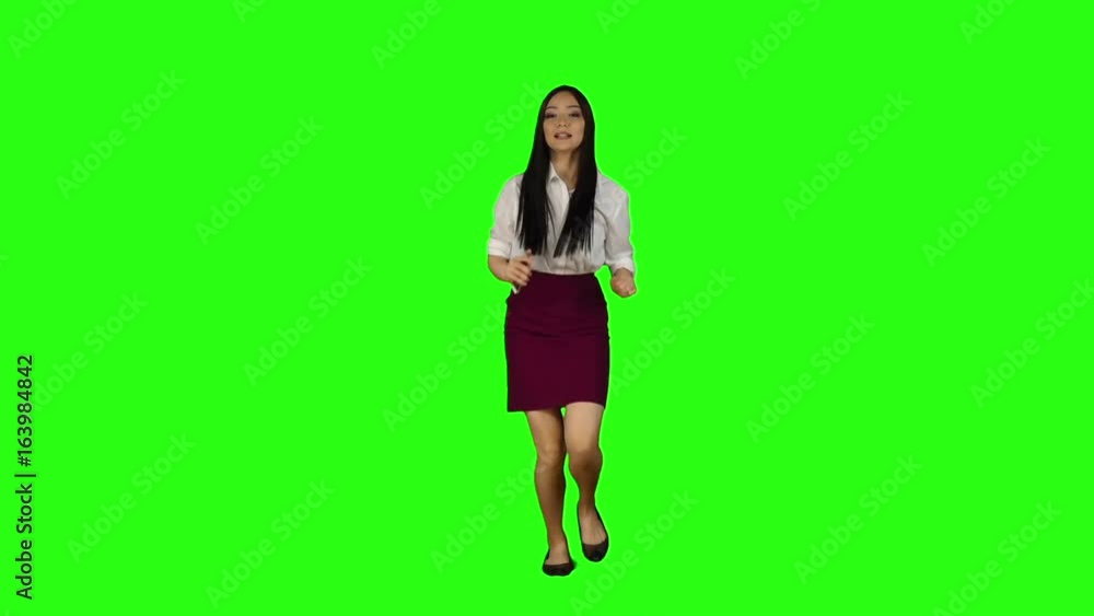 Girl walking along the road, looking at the clock starts to run. Green screen. Slow motion Girl walking along the road, looking at the clock starts to run. Green screen. Slow motion