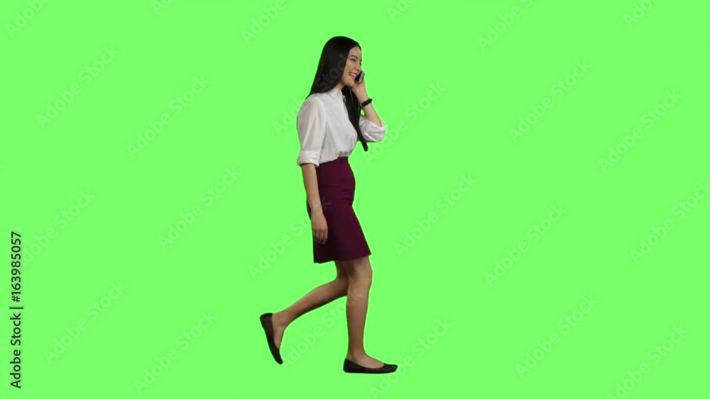 Manager girl goes to her phone rings and she starts talking. Green screen. Side view. Slow motion Manager girl goes to her phone rings and she starts talking. Green screen. Side view. Slow motion