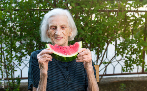 Senior woman eating watermelon outdoors