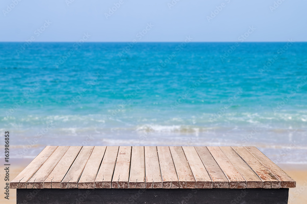 Wooden table with beach sea and sand background Wooden table with beach sea and sand background
