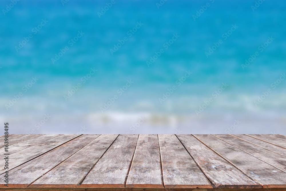 Wooden table with sea, sky and beach background Wooden table with sea, sky and beach background