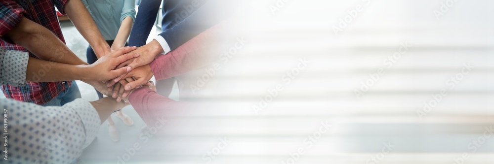 Creative team putting hands together and blurry white transition