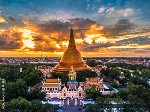 Large golden pagoda Located in the community at sunset , Phra Pathom Chedi , Nakhon Pathom , Thailand .The measure public.Aerial view.Cloudy skies and golden. photo