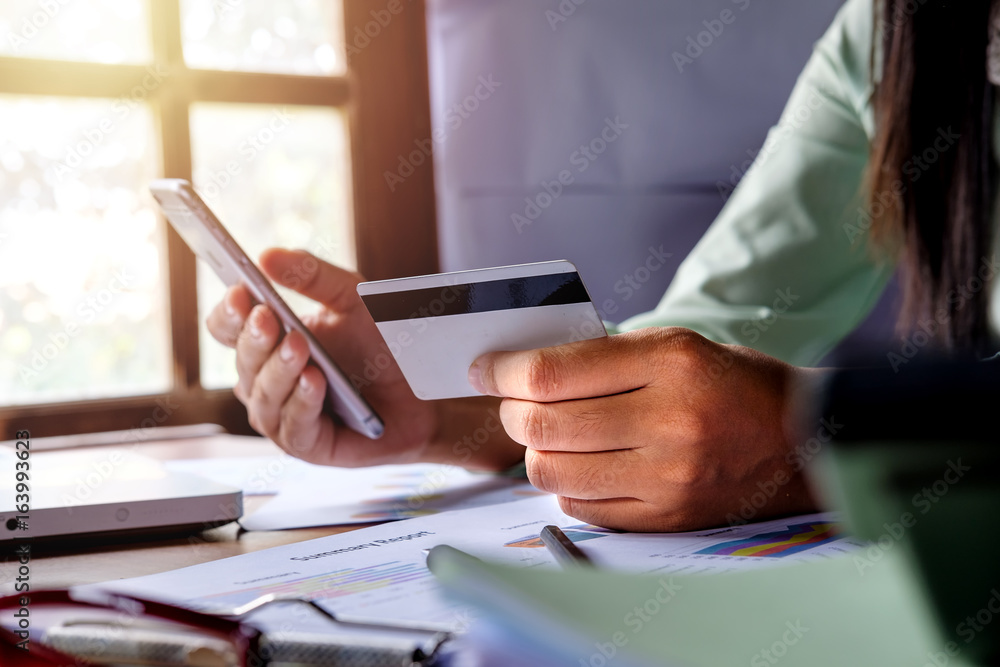 Woman hands using smart phone and holding credit card Woman hands using smart phone and holding credit card