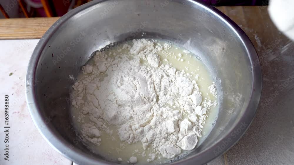 Adding flour to the base for the dough. Kneading dough. UHD real time footage Adding flour to the base for the dough. Kneading dough. UHD real time footage