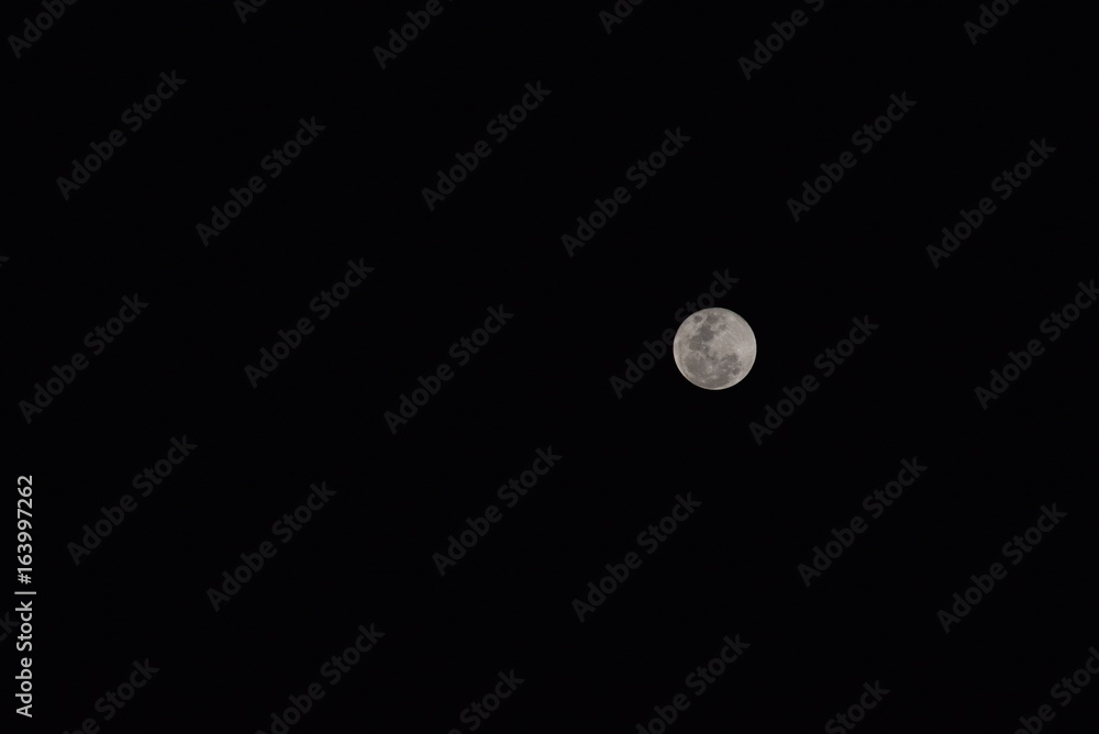 Small Bright White Moon Isolated on Black Background Small Bright White Moon Isolated on Black Background