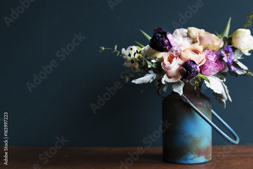 Fototapeta Naklejka Na Ścianę i Meble -  Various fresh flowers arrangement in metalic vase on wooden table