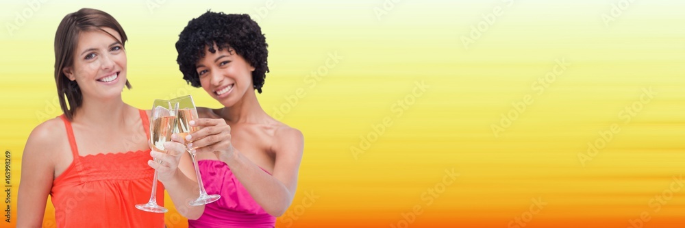 Women toasting against blurry yellow background Women toasting against blurry yellow background