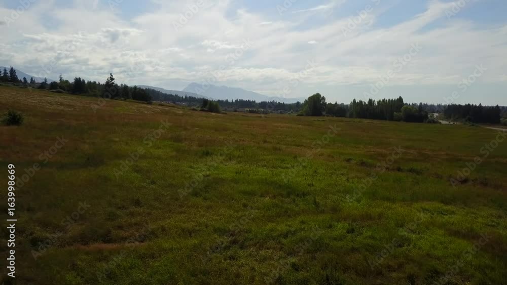 Flying over a pasture and rising to a view of the mountains Flying over a pasture and rising to a view of the mountains