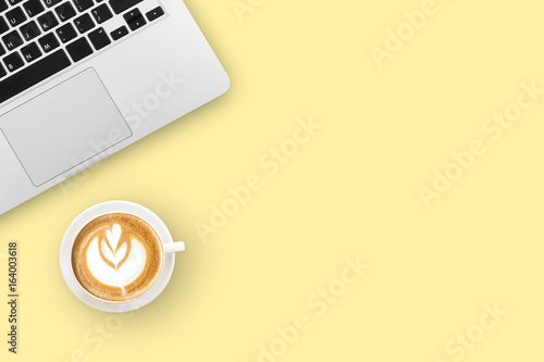 Modern workplace with notebook and coffee cup copy space on color background. Top view. Flat lay style.