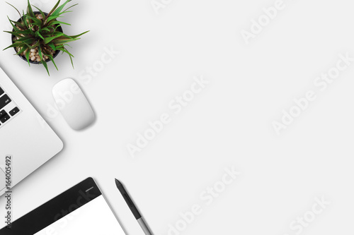 Modern workplace with notebook, little tree, gracphic tablet and graphic pen copy space on gray background. Top view. Flat lay style.