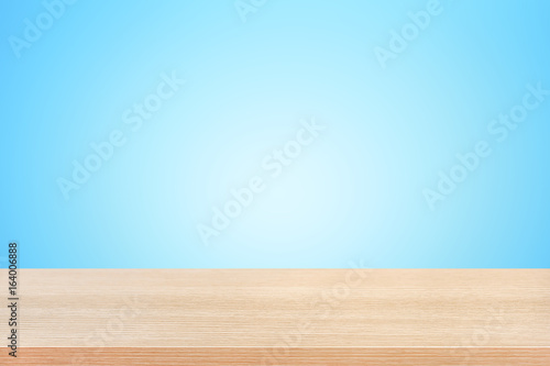 Wood table top on gradient light blue background