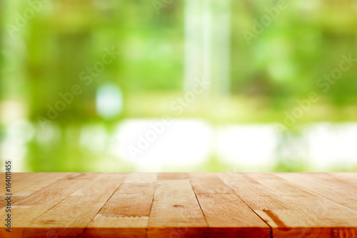 Wood table top on blur green background