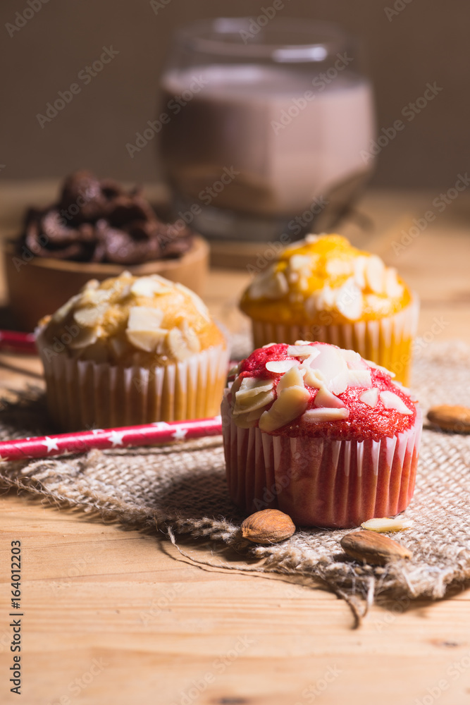 Sweet muffins with almond on wooden table. Sweet muffins with almond on wooden table.