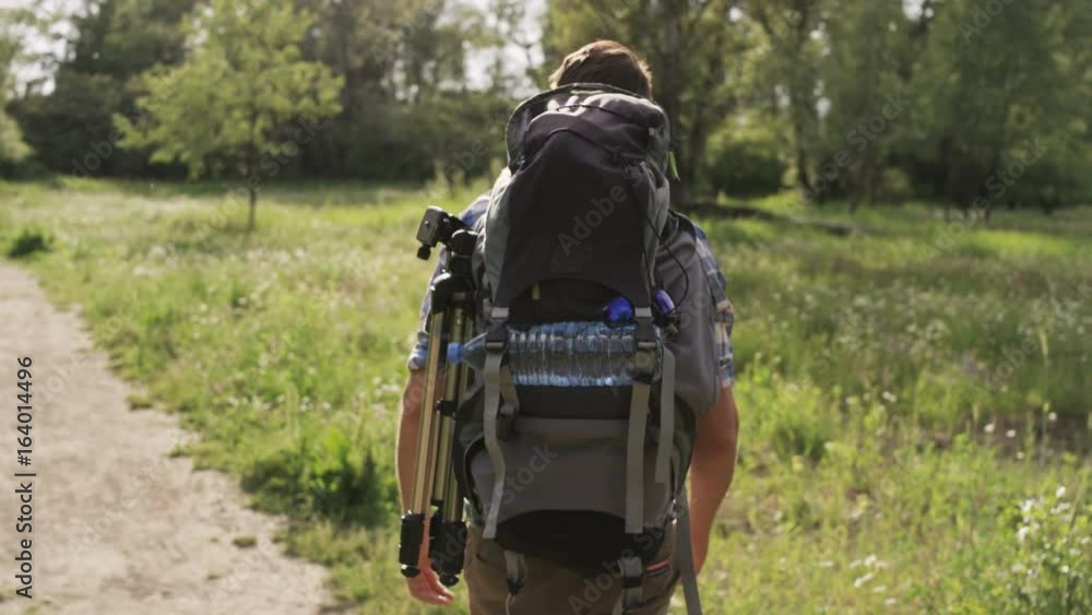 Young Man With a Backpack Walking in the Woods Young Man With a Backpack Walking in the Woods