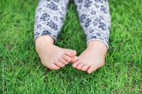 Small feet of a kid on the green grass,Exploring and discovering nature environment and outdoor activity like play, touch and see the real things is the best learning method for children.
