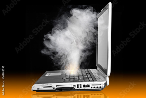 Obraz na płótnie Laptop computer overheated and caught fire, emmiting cloud of smoke, needs repai