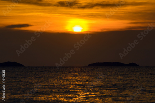 sunset time over the golden sky and sea or ocean water.