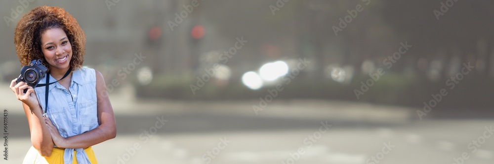 Fototapeta premium Millennial woman with camera against blurry street