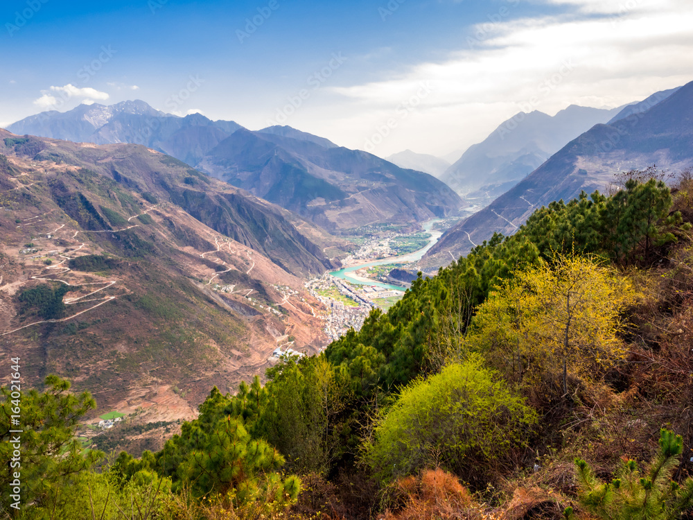 Aerial view of village and river at the valley of high mountain