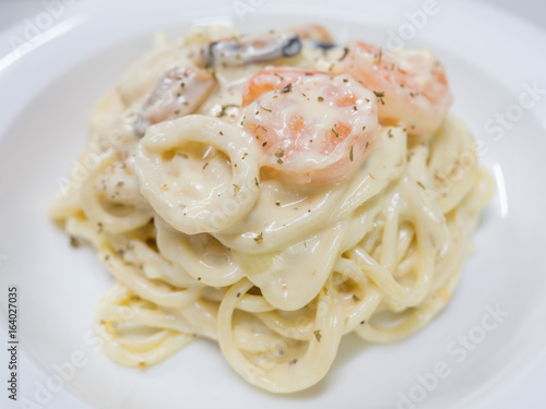 Pasta Carbonara with seafood on a white plate
