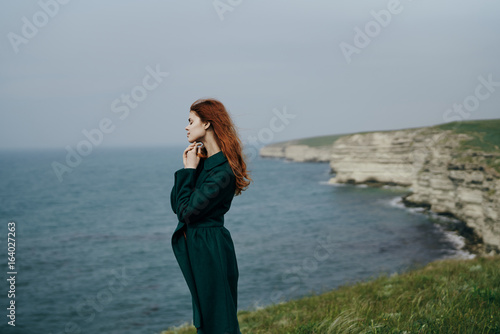 Beautiful young woman on a cliff of a mountain near the sea © SHOTPRIME STUDIO