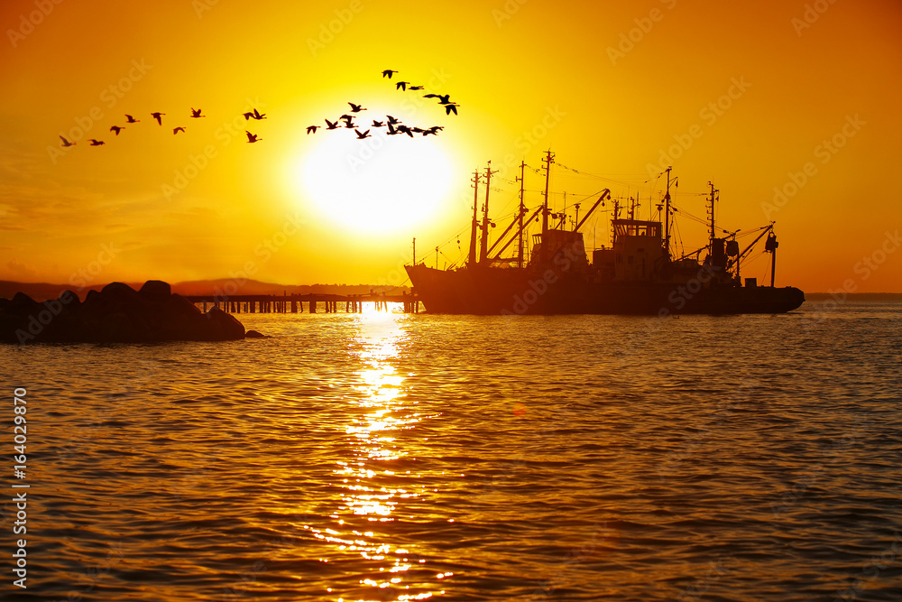 ship at sea on a background of sunset sky