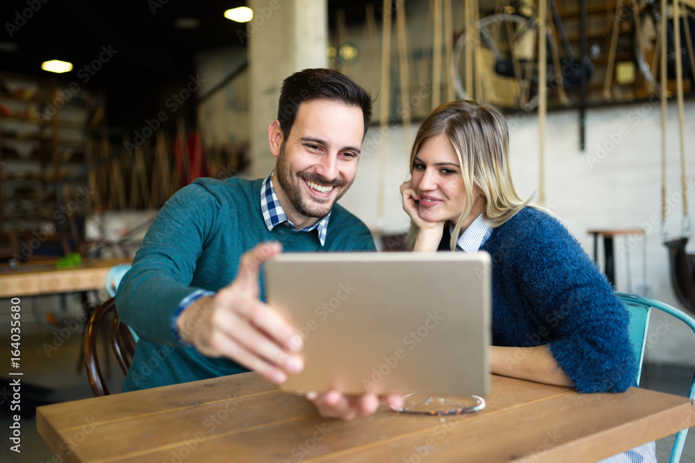 Young attractive man and beautiful woman on date looking on tablet Young attractive man and beautiful woman on date looking on tablet