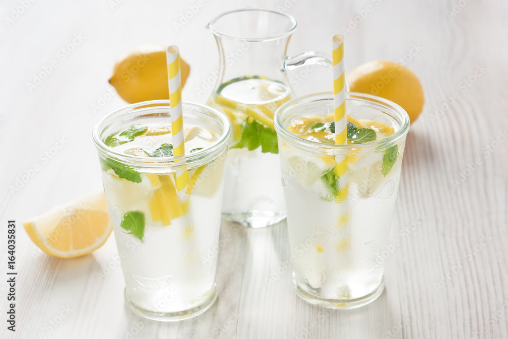 Fresh lemon water drink / Fresh lemon cold water drink lemonade with mint in two glass Fresh lemon water drink / Fresh lemon cold water drink lemonade with mint in two glass