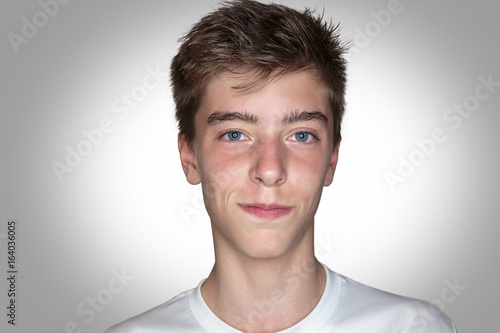 portrait of a smiling young man with gray background