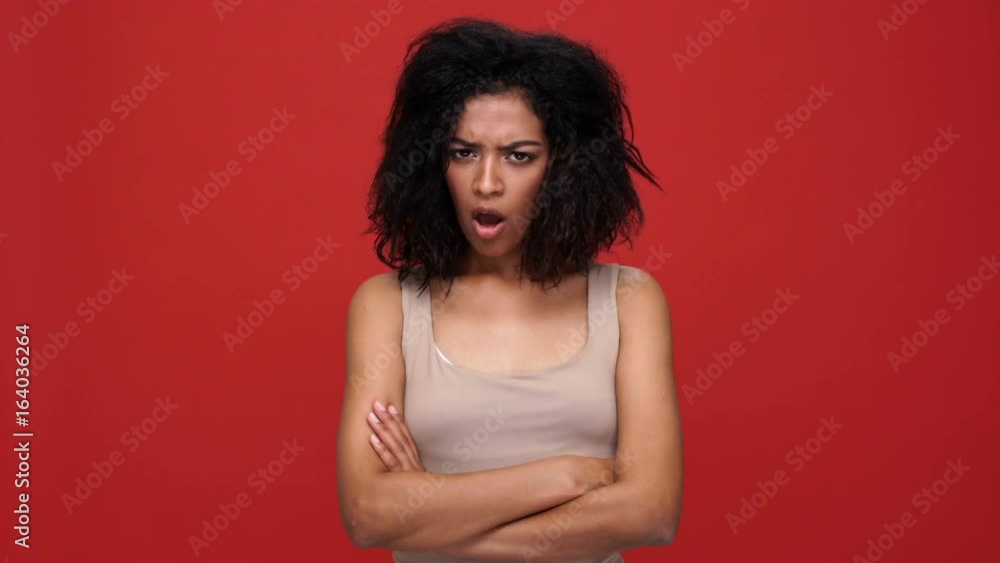 Young angry african woman with arms crossed says no over red background Young angry african woman with arms crossed says no over red background