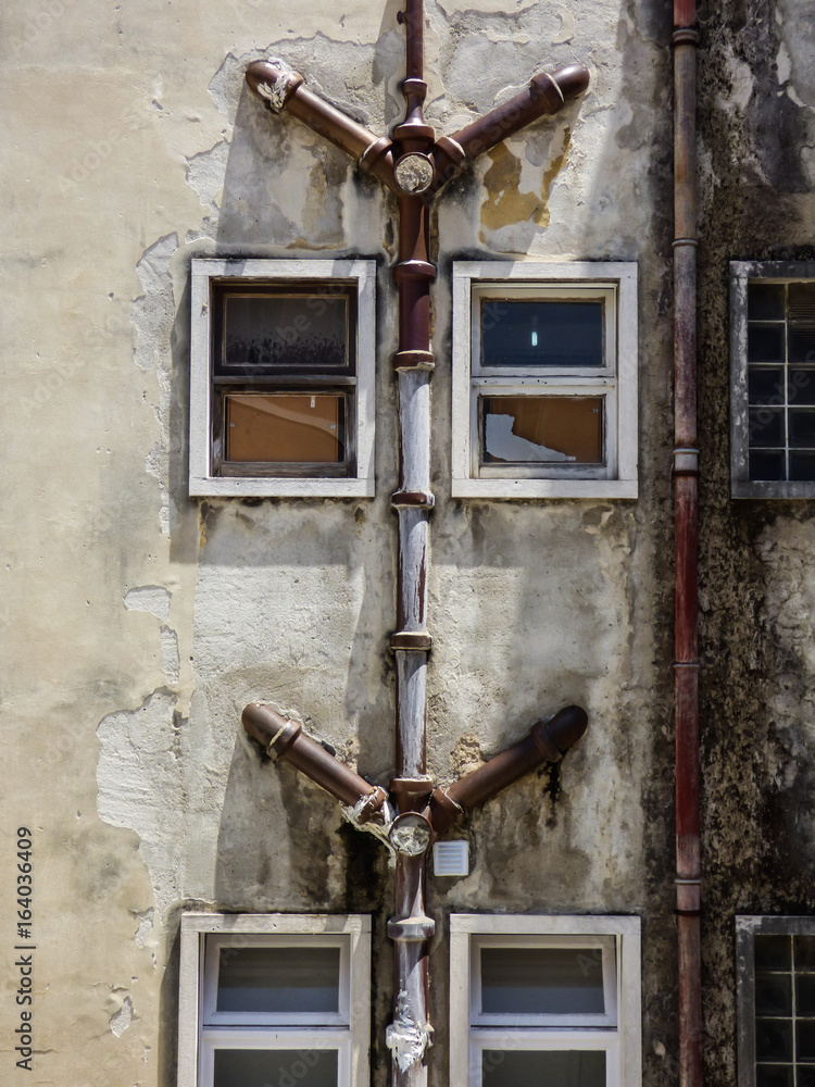 Old decaying apartment building in Lisbon with exposed pipes