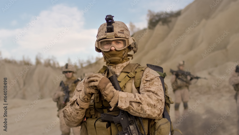 Soldier Preparing a Grenade for Throwing during Combat in the Desert. Soldier Preparing a Grenade for Throwing during Combat in the Desert.