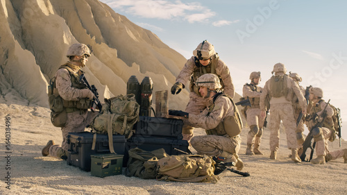 Canvas Print Soldiers are Using Laptop Computer for Surveillance During Military Operation in the Desert