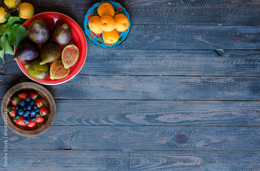 Fresh figs with peaches, apricots, blueberries, strawberries, on a wooden background. Fresh figs with peaches, apricots, blueberries, strawberries, on a wooden background.