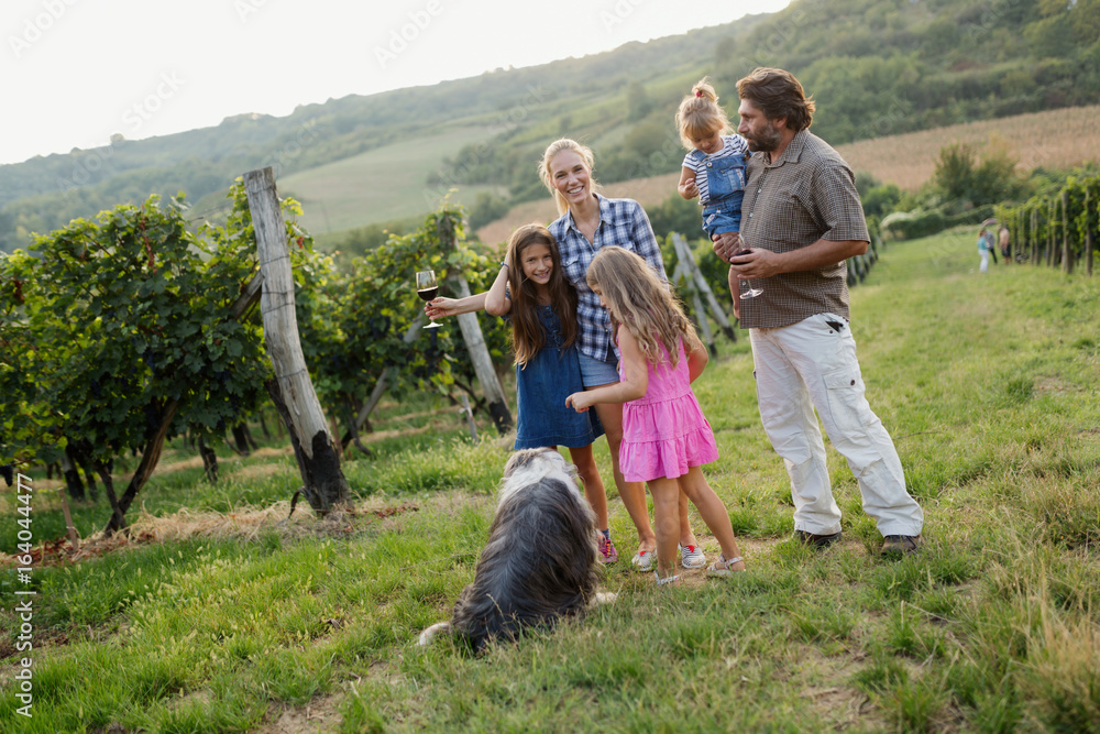 Happy family enjoys walk in vineyard