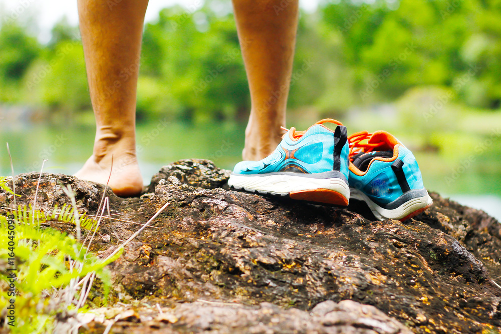 Stock Photo - Shoes on the rocks next to a mountain lake Stock Photo - Shoes on the rocks next to a mountain lake