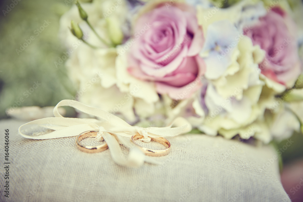 Cuscino delle fedi con bouquet sullo sfondo Cuscino delle fedi con bouquet sullo sfondo