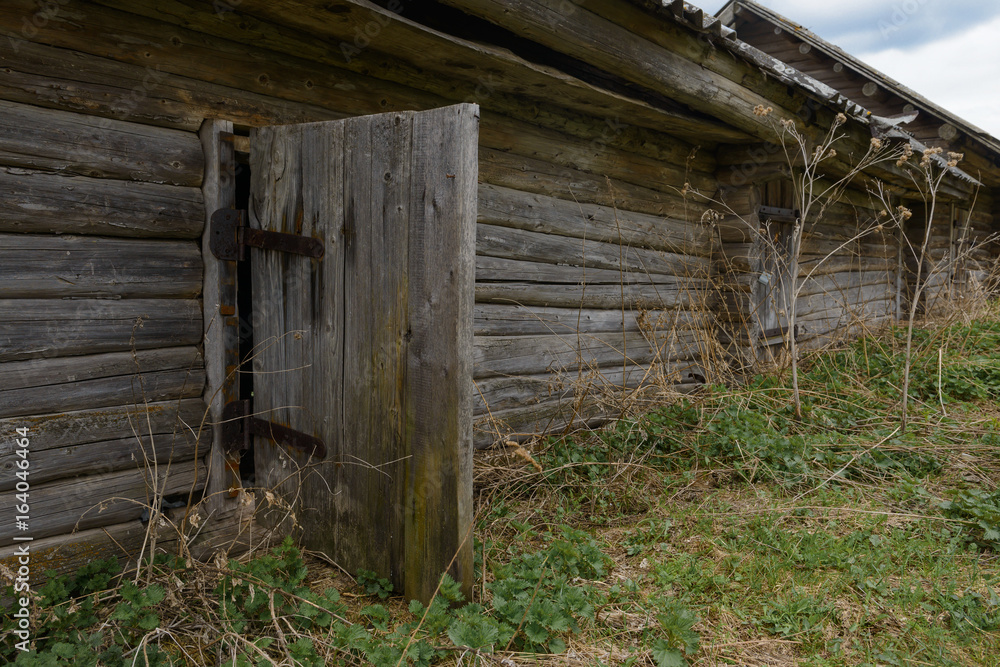 Old dilapidated wooden house with an open door Old dilapidated wooden house with an open door
